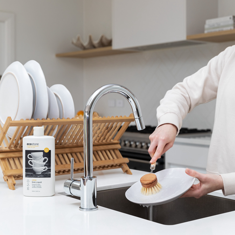 person at kitchen sink using ecostore dishwashing liquic