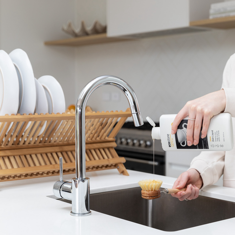 person at kitchen sink using ecostore dishwashing liquic